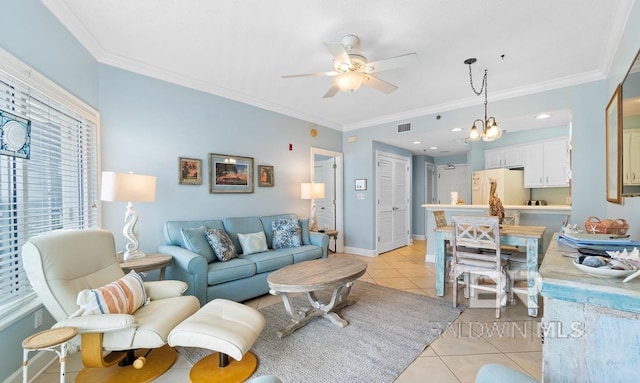 living room with ornamental molding, ceiling fan with notable chandelier, and light tile patterned floors