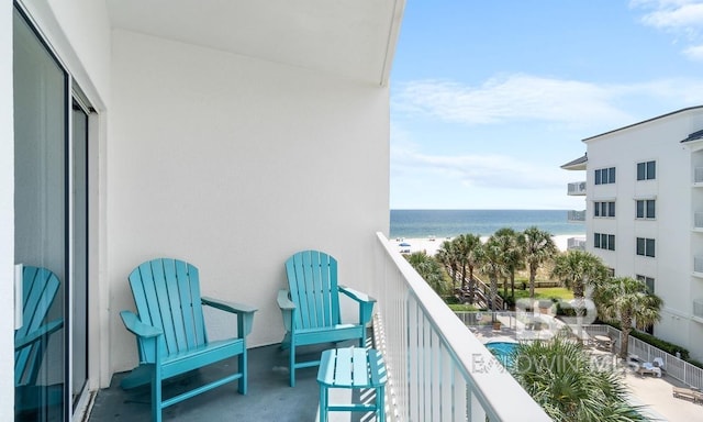 balcony featuring a water view and a beach view