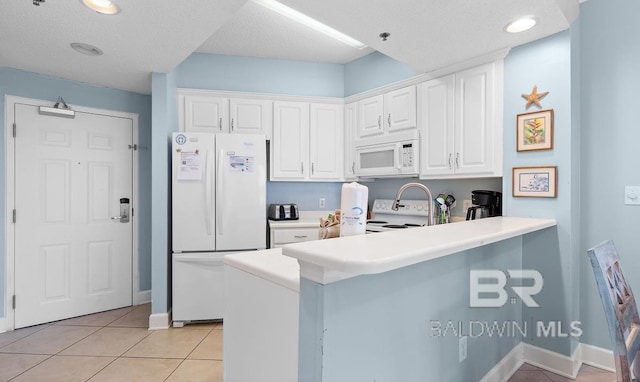 kitchen featuring white appliances, a textured ceiling, kitchen peninsula, white cabinetry, and light tile patterned floors