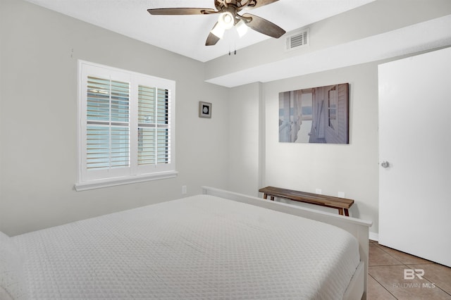 bedroom featuring tile patterned floors, visible vents, and a ceiling fan