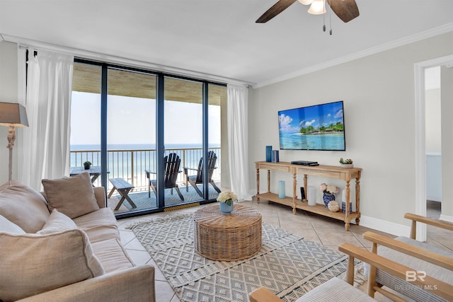 living area featuring baseboards, light tile patterned flooring, ceiling fan, expansive windows, and crown molding