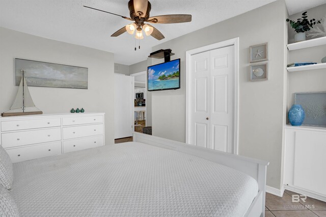 bedroom with a closet, ceiling fan, and tile patterned flooring