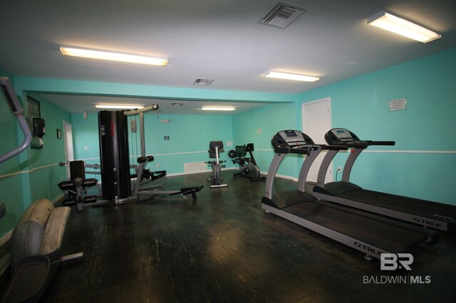 exercise room featuring wood finished floors and visible vents