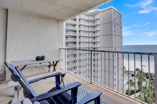 balcony featuring a beach view and a water view