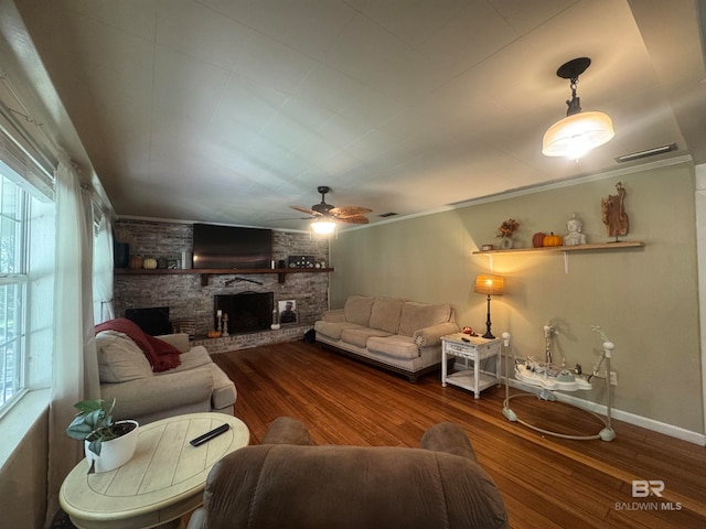 living room with crown molding, hardwood / wood-style flooring, a fireplace, and ceiling fan