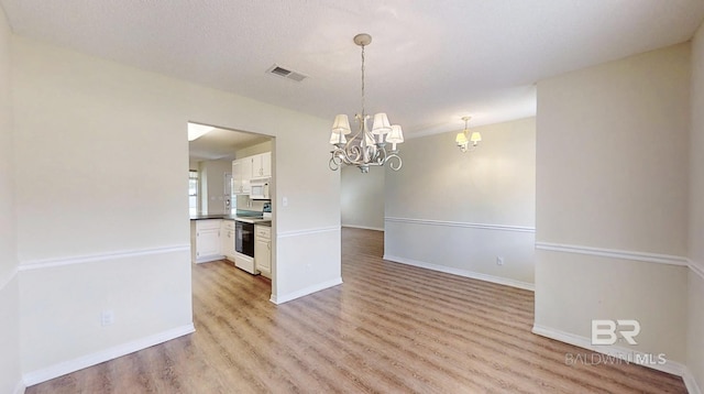 33580 Woodlands Dr, Lillian, AL 36549 - unfurnished room with a chandelier, light wood-type flooring, and baseboards