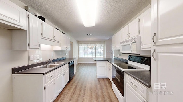 33580 Woodlands Dr, Lillian, AL 36549 - kitchen with white microwave, range with electric cooktop, a sink, black dishwasher, and dark countertops