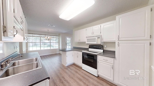 33580 Woodlands Dr, Lillian, AL 36549 - kitchen with white microwave, range with electric cooktop, a sink, dark countertops, and a textured ceiling