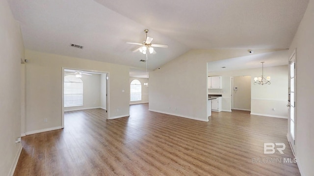 33580 Woodlands Dr, Lillian, AL 36549 - unfurnished living room with a ceiling fan, a chandelier, light wood-type flooring, lofted ceiling, and baseboards