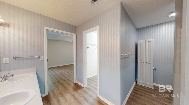 33580 Woodlands Dr, Lillian, AL 36549 - full bath with wood finished floors, a textured ceiling, double vanity, and baseboards