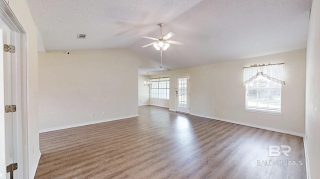 33580 Woodlands Dr, Lillian, AL 36549 - unfurnished room featuring a ceiling fan, wood finished floors, baseboards, lofted ceiling, and a chandelier