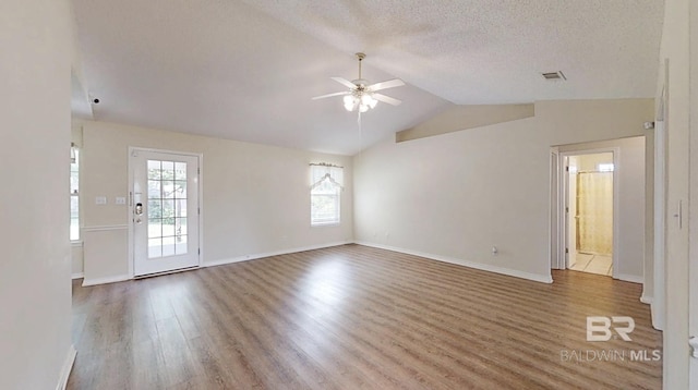 33580 Woodlands Dr, Lillian, AL 36549 - unfurnished living room featuring a ceiling fan, wood finished floors, vaulted ceiling, baseboards, and a textured ceiling