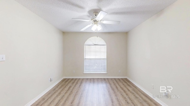 33580 Woodlands Dr, Lillian, AL 36549 - unfurnished room with light wood finished floors, a textured ceiling, a ceiling fan, and baseboards