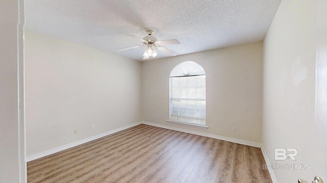 33580 Woodlands Dr, Lillian, AL 36549 - empty room with wood finished floors, a textured ceiling, a ceiling fan, and baseboards