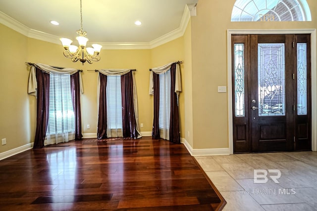 entrance foyer with a notable chandelier, ornamental molding, and hardwood / wood-style floors