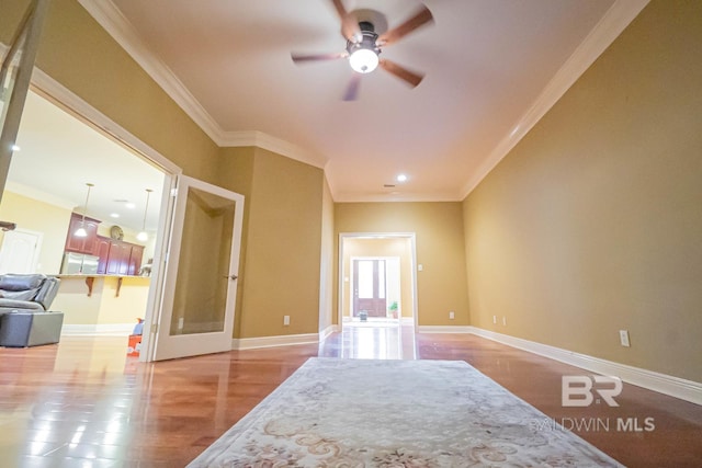 spare room featuring ceiling fan, crown molding, and light wood-type flooring