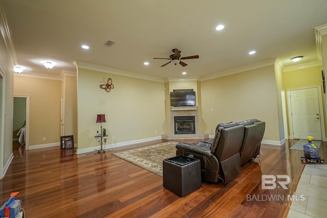 living room featuring crown molding, dark hardwood / wood-style floors, and ceiling fan