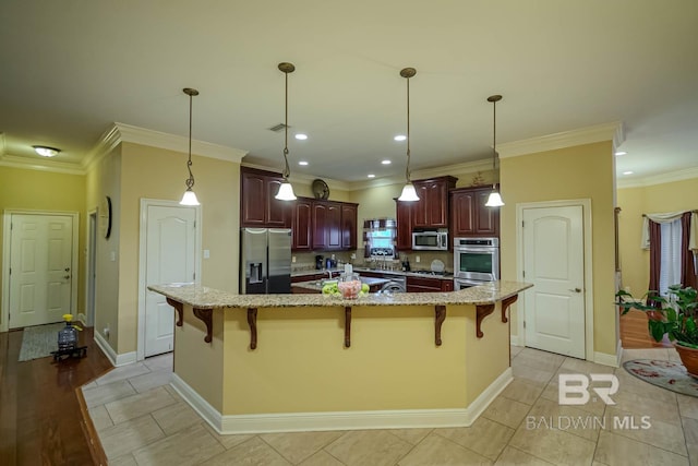 kitchen featuring a large island, appliances with stainless steel finishes, and a kitchen bar