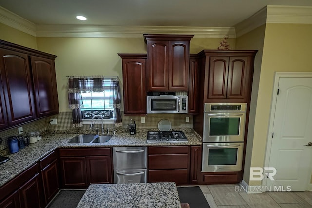 kitchen with sink, backsplash, light stone counters, crown molding, and stainless steel appliances