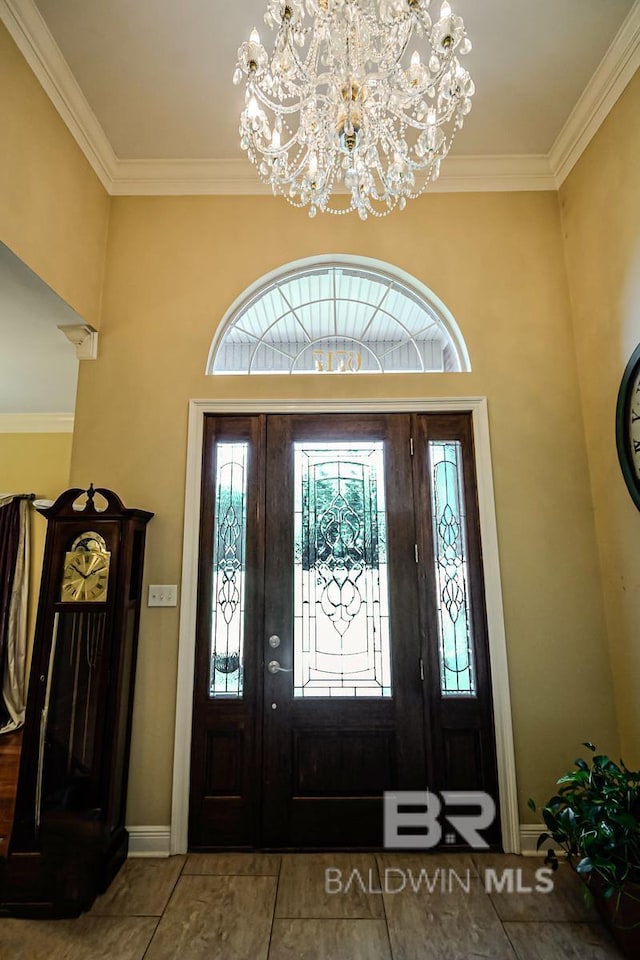 entryway featuring crown molding and an inviting chandelier