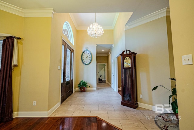 foyer with light wood-type flooring, ornamental molding, an inviting chandelier, and plenty of natural light