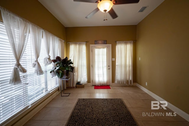 tiled entryway featuring ceiling fan and a wealth of natural light