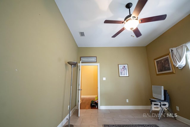 exercise room with ceiling fan and light tile patterned floors