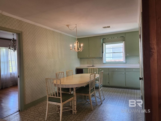 dining area featuring a notable chandelier, sink, ornamental molding, and dark hardwood / wood-style flooring