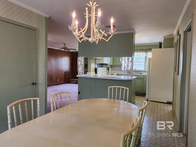 dining room featuring ceiling fan with notable chandelier and ornamental molding