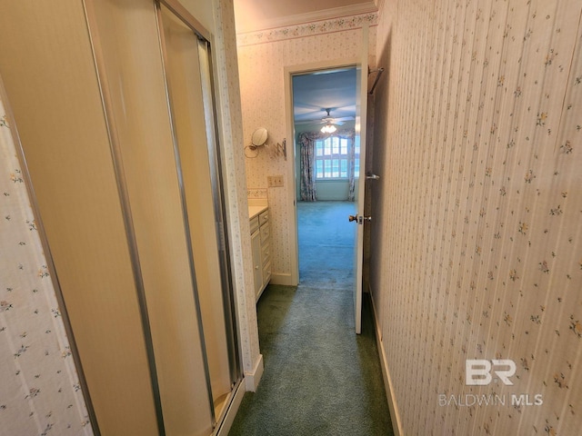 hall with ornamental molding and carpet flooring