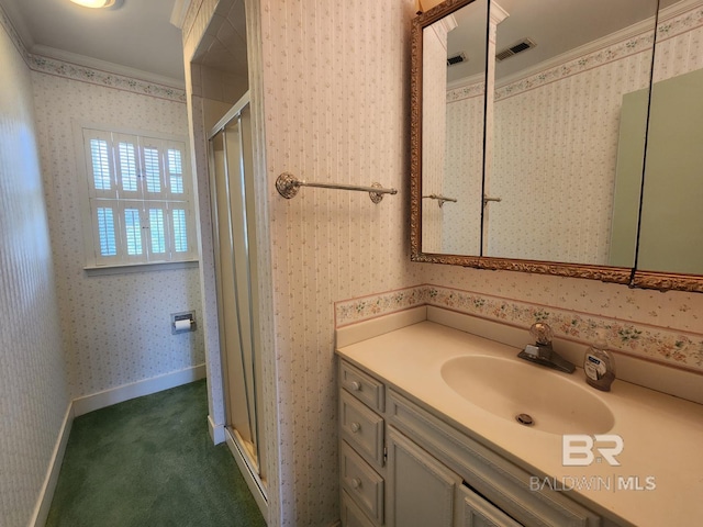 bathroom featuring vanity, crown molding, and a shower with door