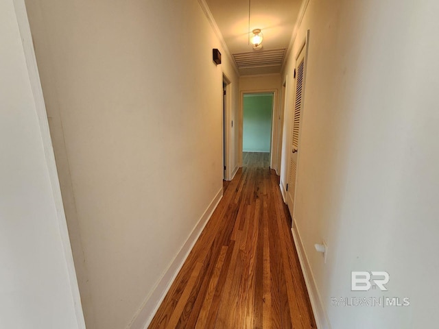 hallway featuring ornamental molding and hardwood / wood-style floors