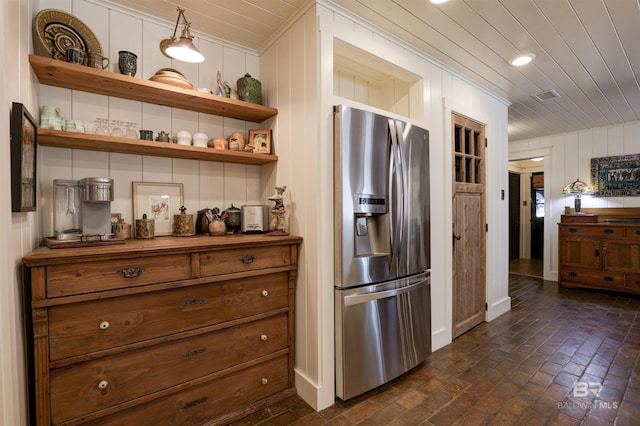 kitchen featuring open shelves, brick floor, stainless steel fridge, and wooden ceiling