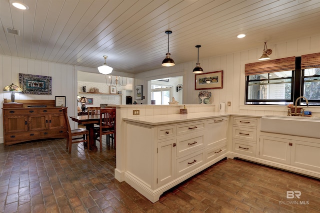 kitchen featuring a healthy amount of sunlight, brick floor, visible vents, and a sink