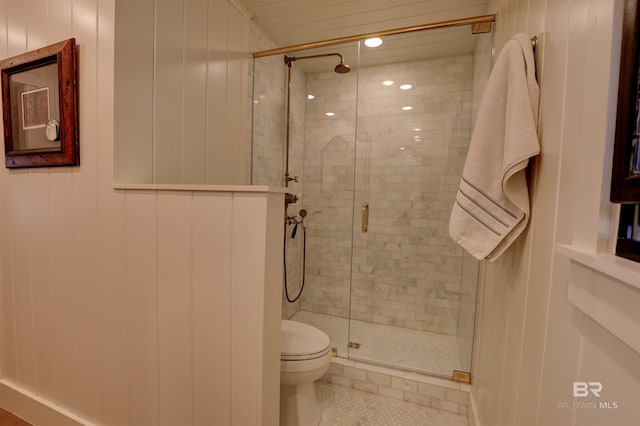 bathroom featuring a stall shower, toilet, and tile patterned floors