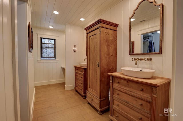 full bathroom featuring baseboards, visible vents, wood ceiling, wood finished floors, and vanity