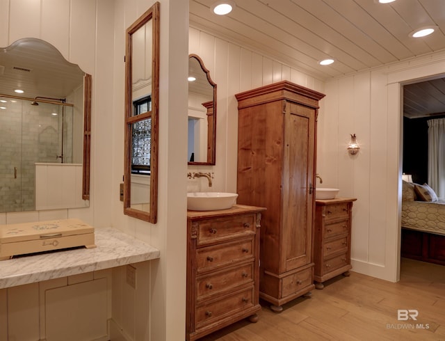 full bath with a stall shower, ensuite bath, wood finished floors, vanity, and recessed lighting