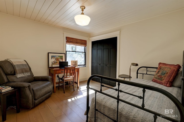 bedroom featuring wooden ceiling, wood-type flooring, and a closet