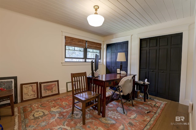 dining space with wooden ceiling, crown molding, and wood finished floors