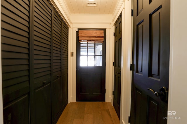 doorway to outside featuring ornamental molding, wood finished floors, and visible vents