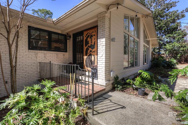 doorway to property featuring brick siding