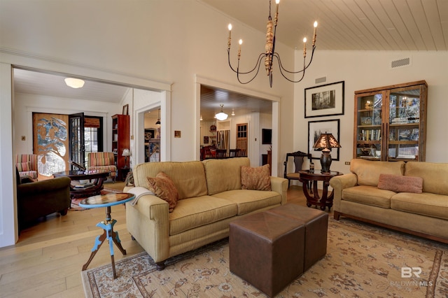 living room featuring light wood-style floors, visible vents, high vaulted ceiling, and an inviting chandelier