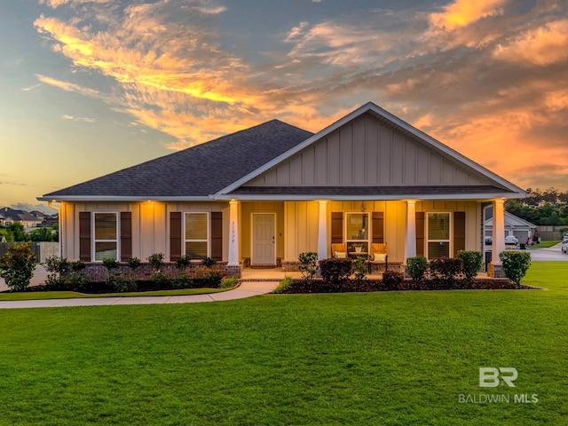 31579 Shadwell Dr, Spanish Fort, AL 36527 - view of front of property with roof with shingles, board and batten siding, a porch, and a front lawn