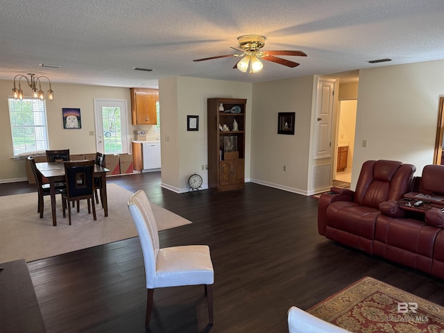 28712 Canal Rd, Orange Beach, AL 36561 - living room featuring a ceiling fan, baseboards, a textured ceiling, dark wood-style flooring, and a chandelier