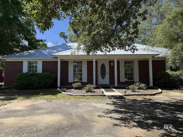 28712 Canal Rd, Orange Beach, AL 36561 - ranch-style home featuring brick siding, metal roof, and covered porch