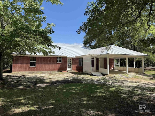 28712 Canal Rd, Orange Beach, AL 36561 - back of property featuring metal roof, brick siding, and a yard