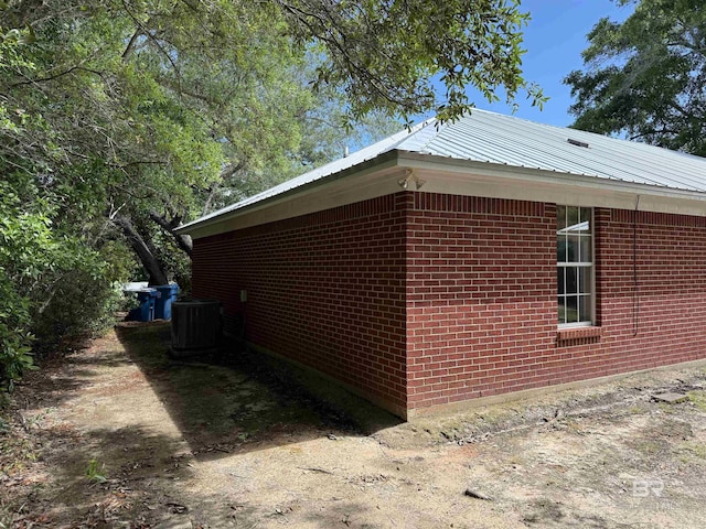 28712 Canal Rd, Orange Beach, AL 36561 - view of side of property featuring central AC unit, metal roof, and brick siding