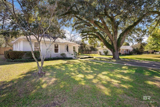 view of front of property with crawl space, fence, and a front lawn