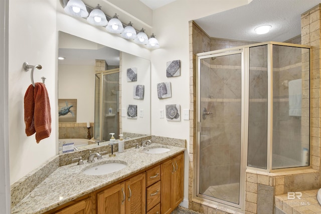 bathroom featuring a sink, a textured ceiling, and a shower stall