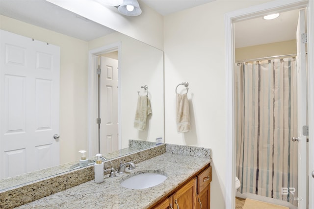 bathroom with toilet, vanity, and curtained shower